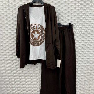 Conjunto de pantalón y chaqueta marrón oscuro junto a una camiseta con dibujo